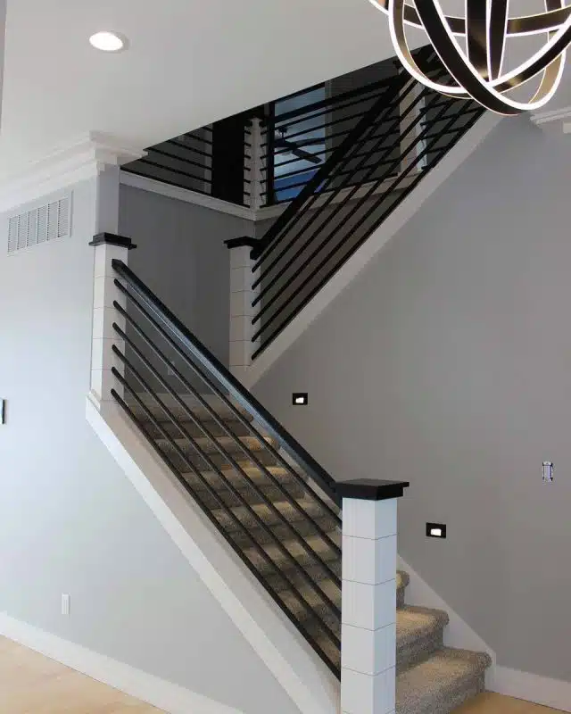 Interior staircase and customized light fixture in custom-built Winona Lake home.
