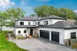 Exterior of Winona Lake two-story custom-built home with white siding and black trim.