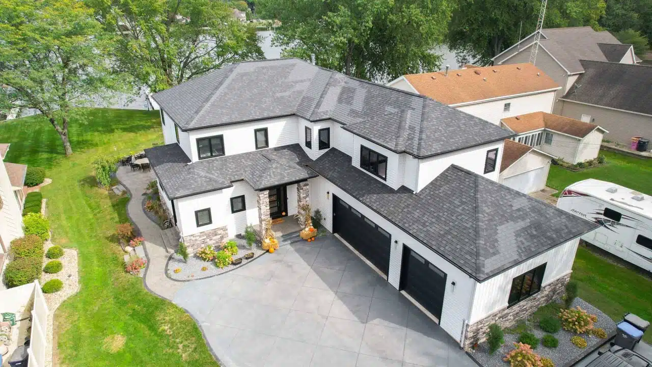 Aerial exterior photo of Winona Lake two-story custom-built home with white siding and black trim.