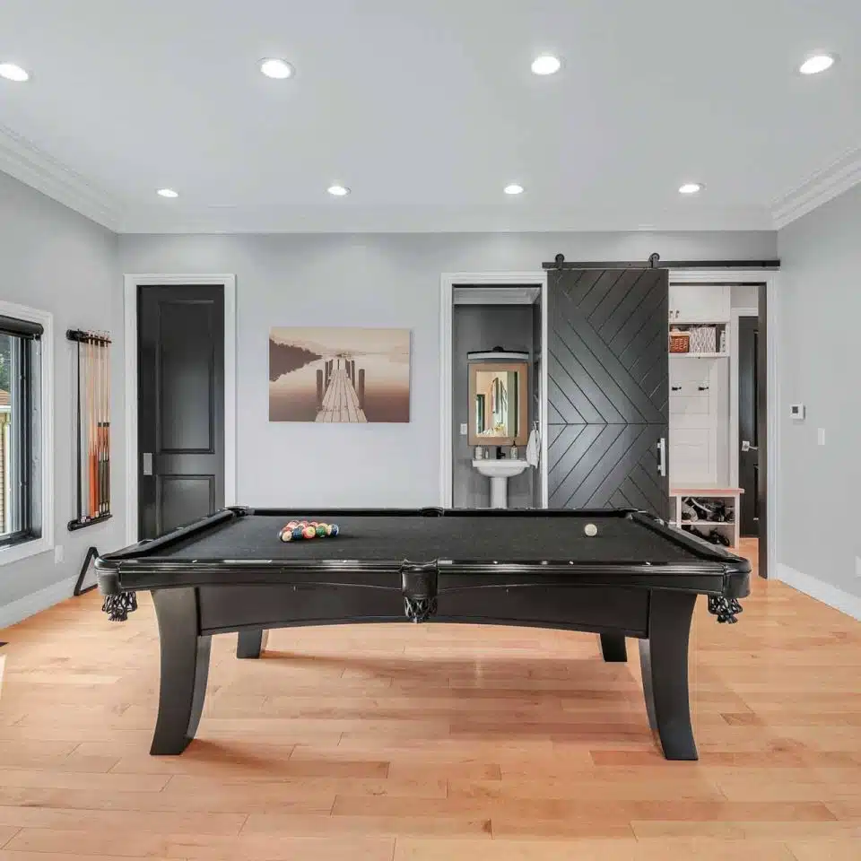 Interior photo of the game room, pool table, and attached bathroom in a custom-built home.